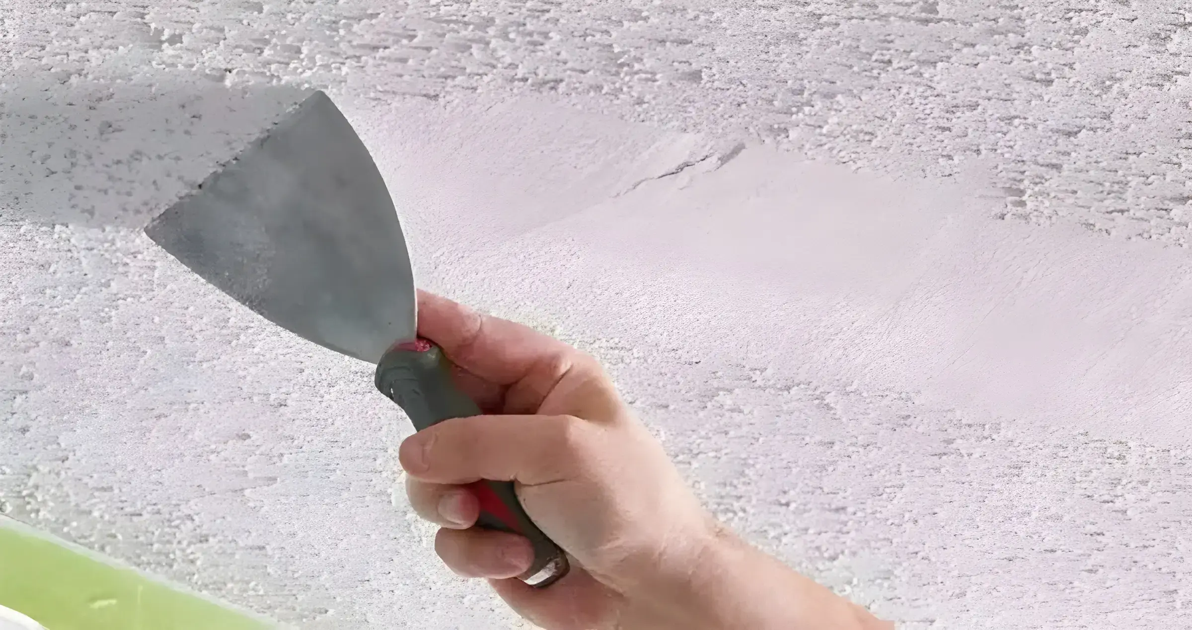 Los Pintores en Córdoba eliminando el gotelé con espátula para dejar la pared lisa